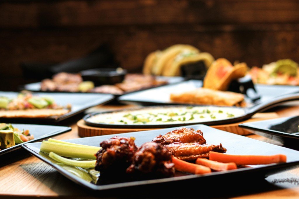 Assortment of Mexican dishes including queso fundido, enchiladas, nachos and chicken wings at Tequila Fuego Longview